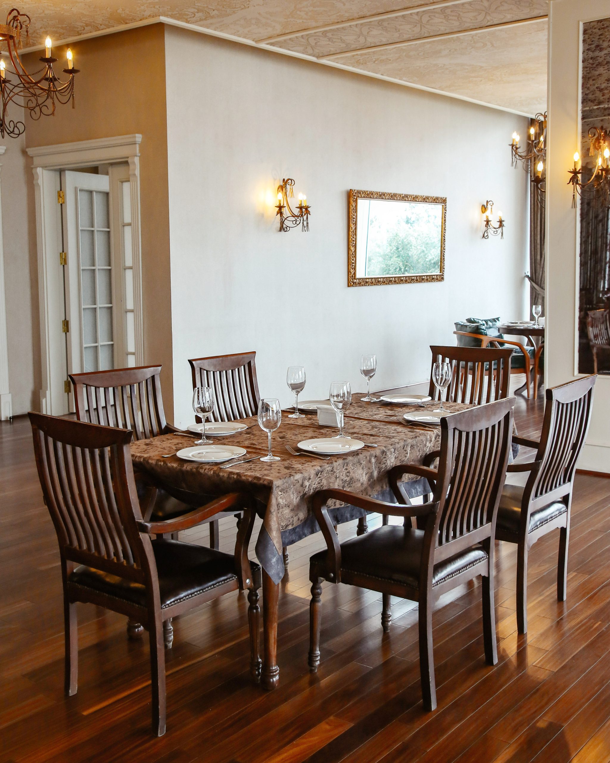 restaurant table with wooden chairs placed in hall decorated in classical style